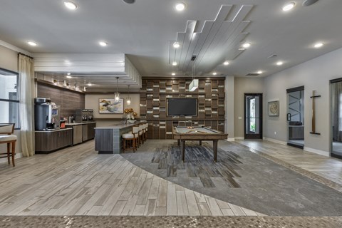 a clubhouse with a dining area and a kitchen with a tv
