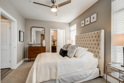 A bedroom with a large bed and a ceiling fan.