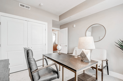 A modern dining room with a wooden table and leather chairs.