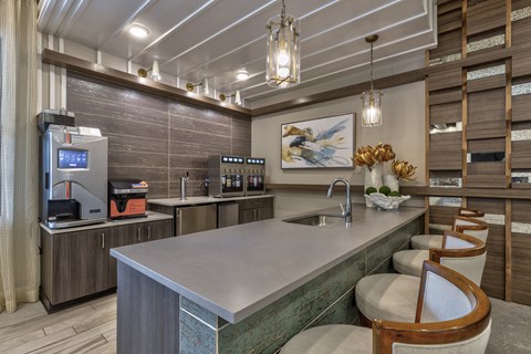 a kitchen with a counter and chairs and a coffee machine