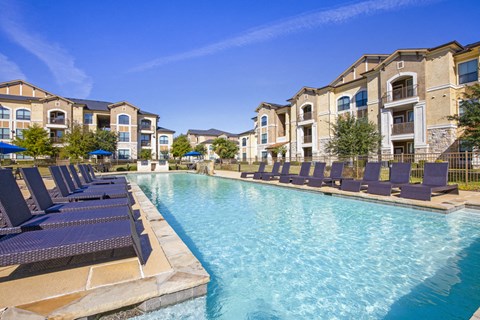 Swimming pool with lounge chairs and native surrounding landscape