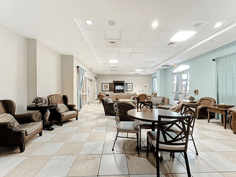 A spacious living room with a variety of furniture including chairs, couches, and tables.