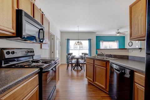 A kitchen with wooden cabinets and a black stove top oven.