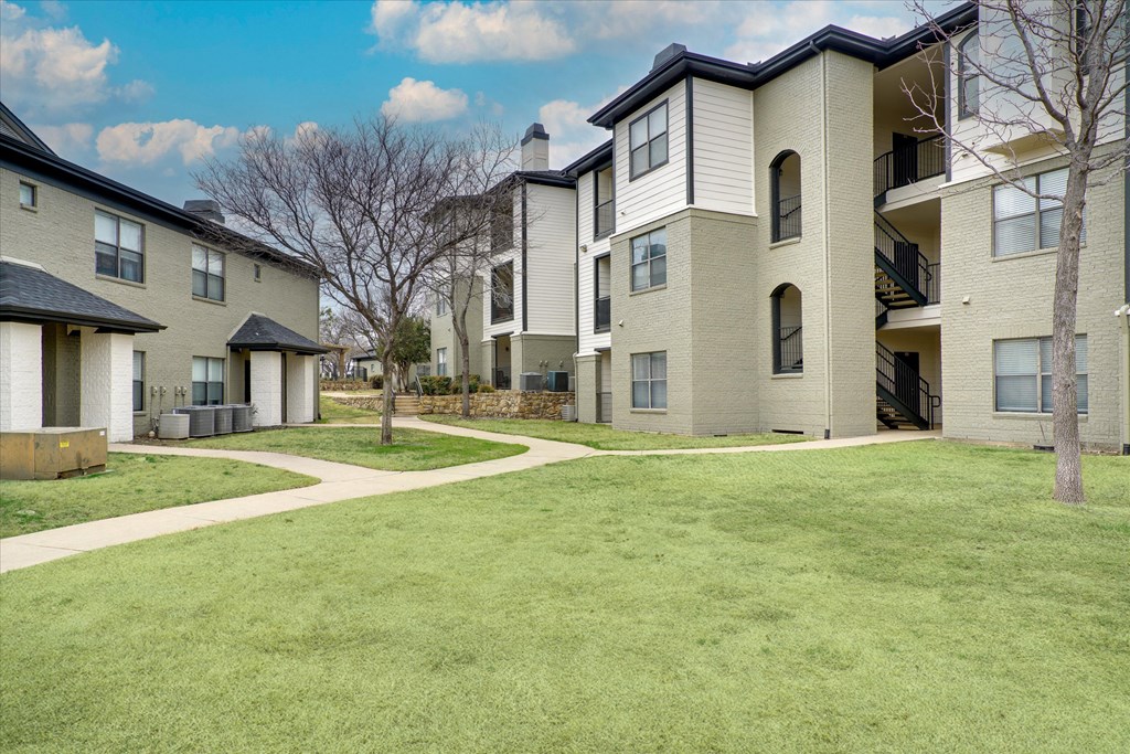 Apartment complex with a green lawn in front.