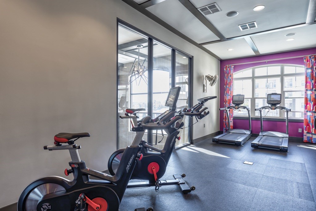 A gym with exercise equipment and a window.