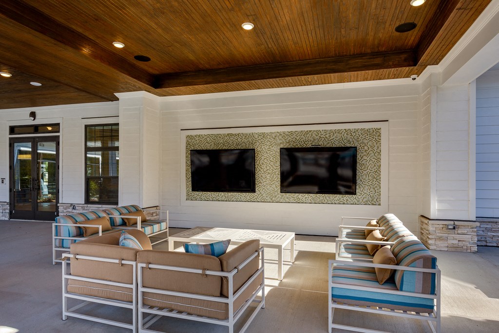 a covered patio with couches and a television