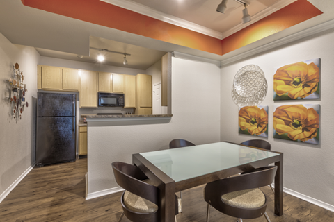 A kitchen with a table and chairs.