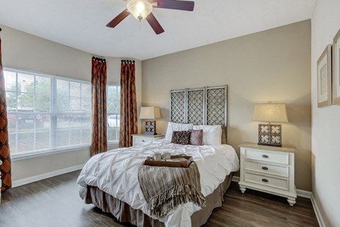 A bedroom with a large bed and a ceiling fan.