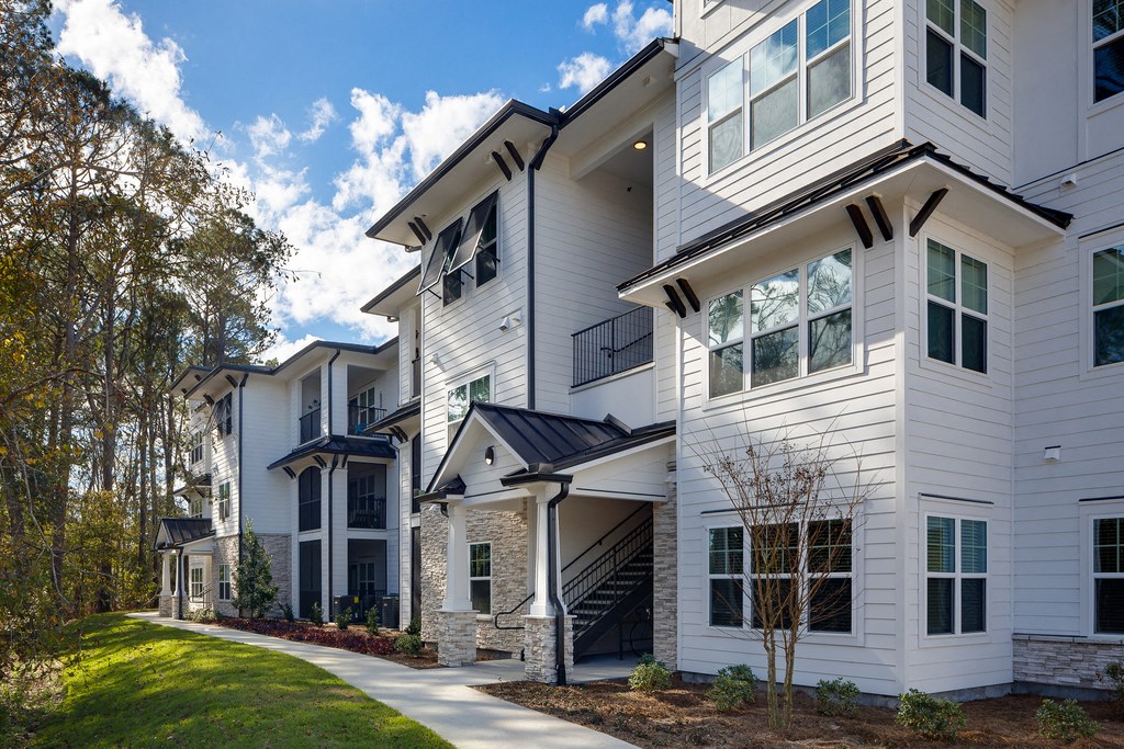 a row of houses with white siding and a sidewalk