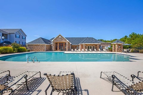 A pool with a stone building in the background.