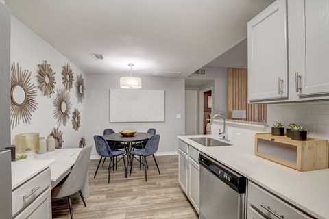 A modern kitchen with a dining table and chairs.