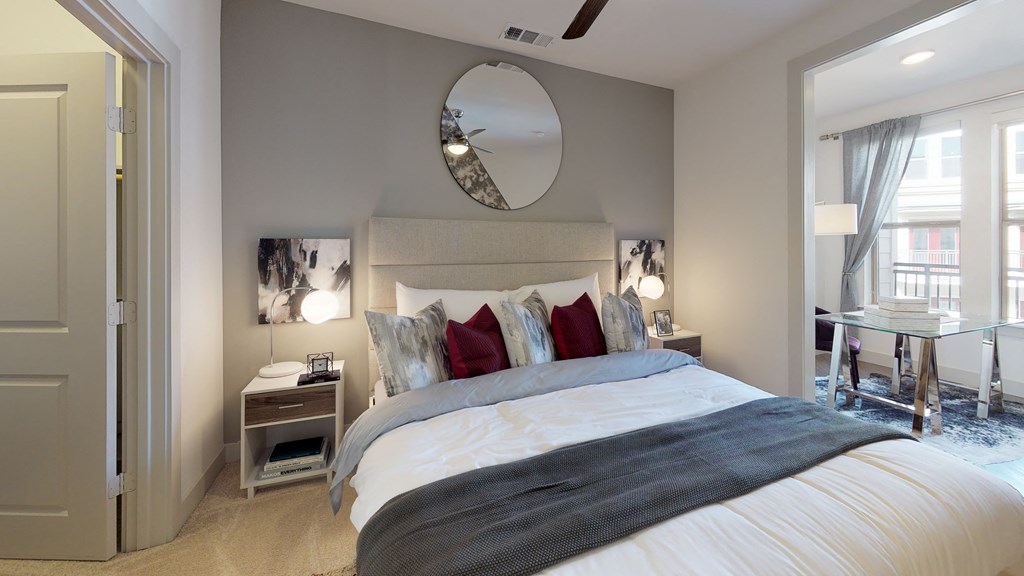 Bedroom area facing bed and office nook with desk and chair