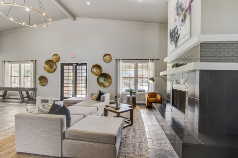 A living room with a grey couch and a fireplace.