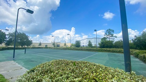 Outdoor tennis court with apartment building exterior in the background