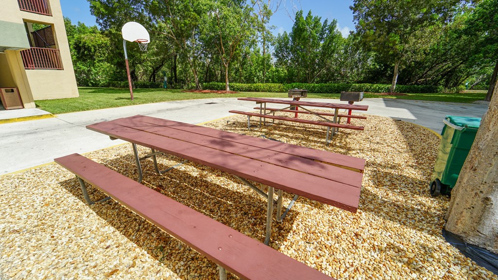 Picnic Tables on Mulch with Basketball Hoop in the Background