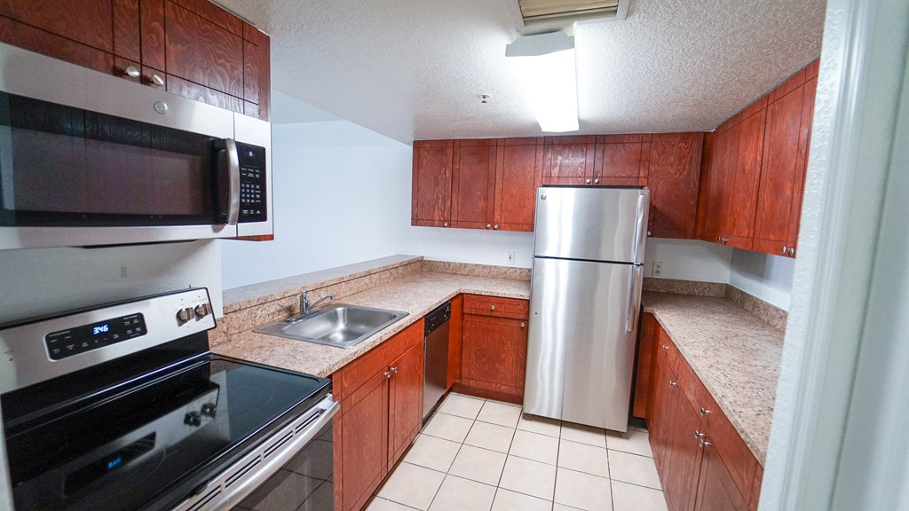 Kitchen with Breakfast Bar, Wood Cabinets, Tan Counters and Stainless Steel Appliances