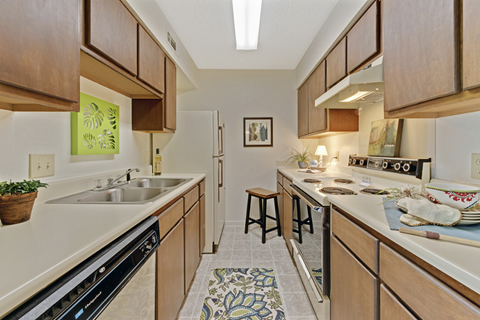 A kitchen with wooden cabinets and a black dishwasher.