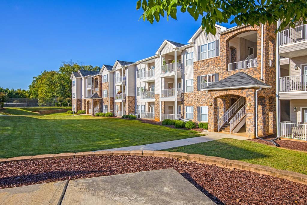 Apartment complex with a walkway in front.