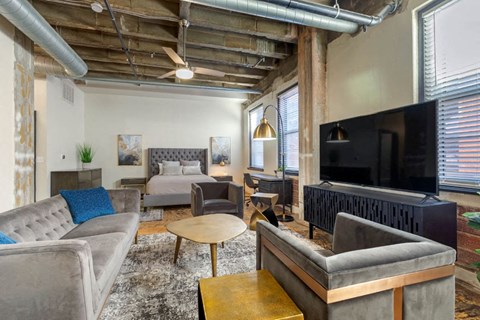 A living room with a grey couch and a wooden coffee table.