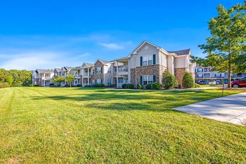 A row of houses with green lawns in front.