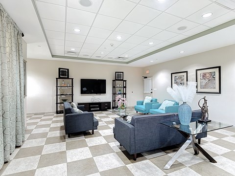 A living room with a checkered floor and a grey couch.