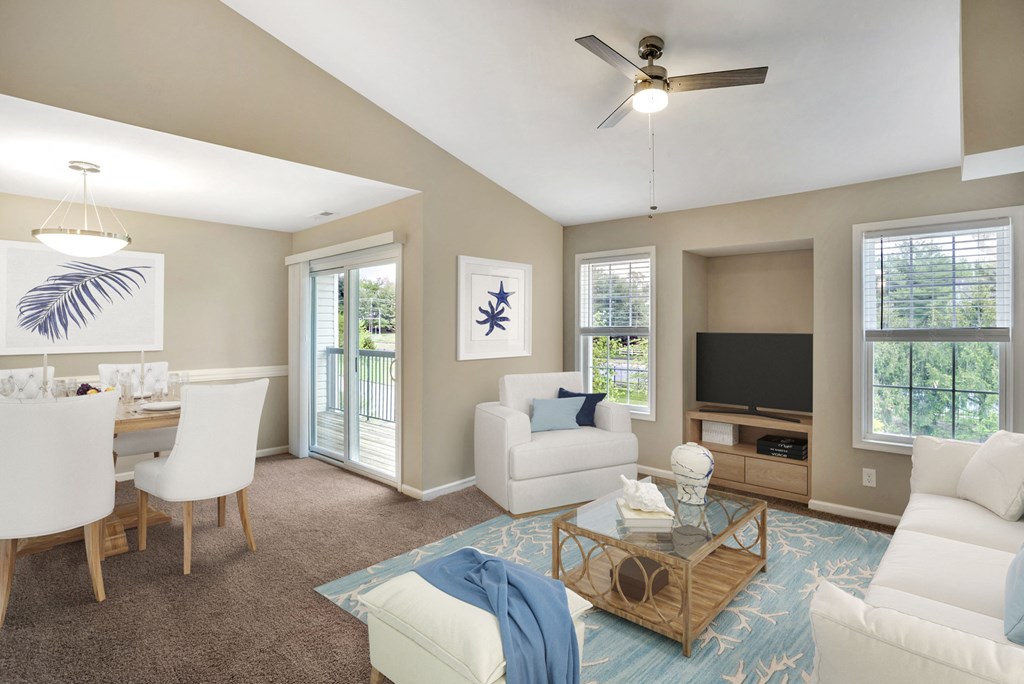 A virtually staged living room and dining room with gray walls with white trim, gray carpet, vaulted ceilings, sliding glass door with vertical blinds, and two windows with blinds.