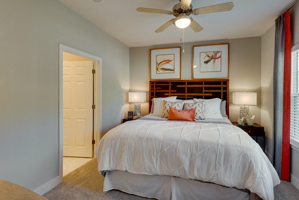 a bedroom with a large bed and a ceiling fan