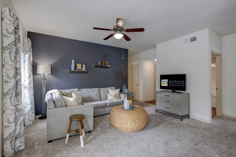 a living room with a couch and a ceiling fan