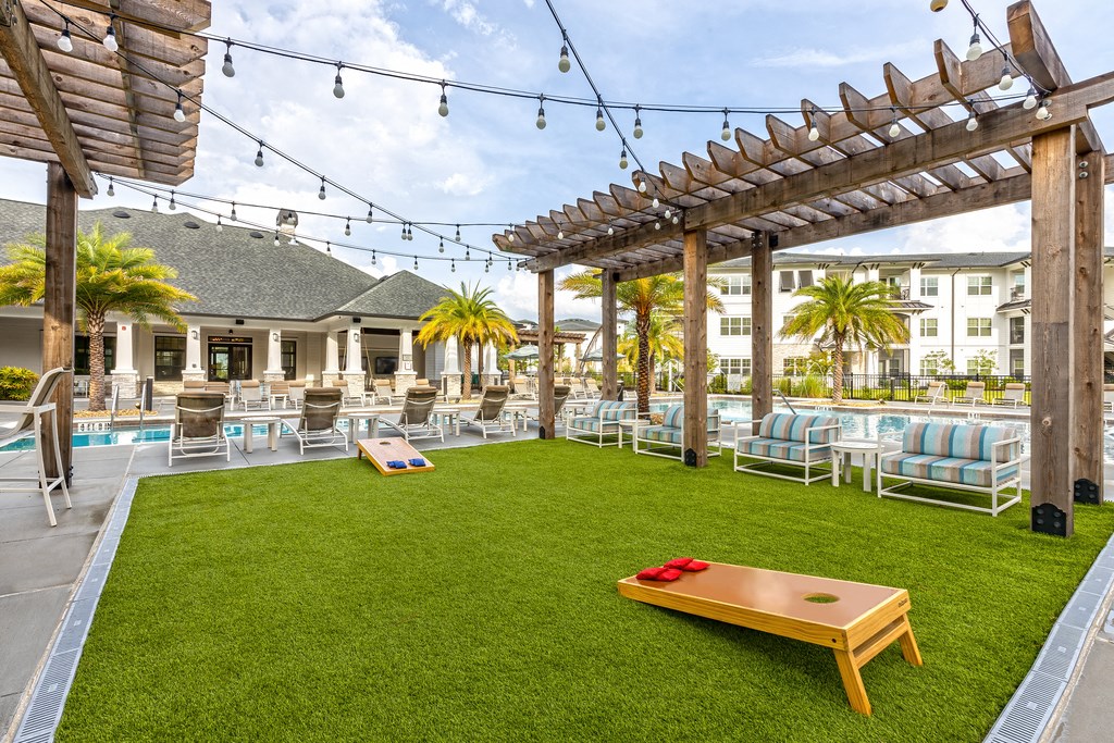 a lawn with chairs and tables and a pool