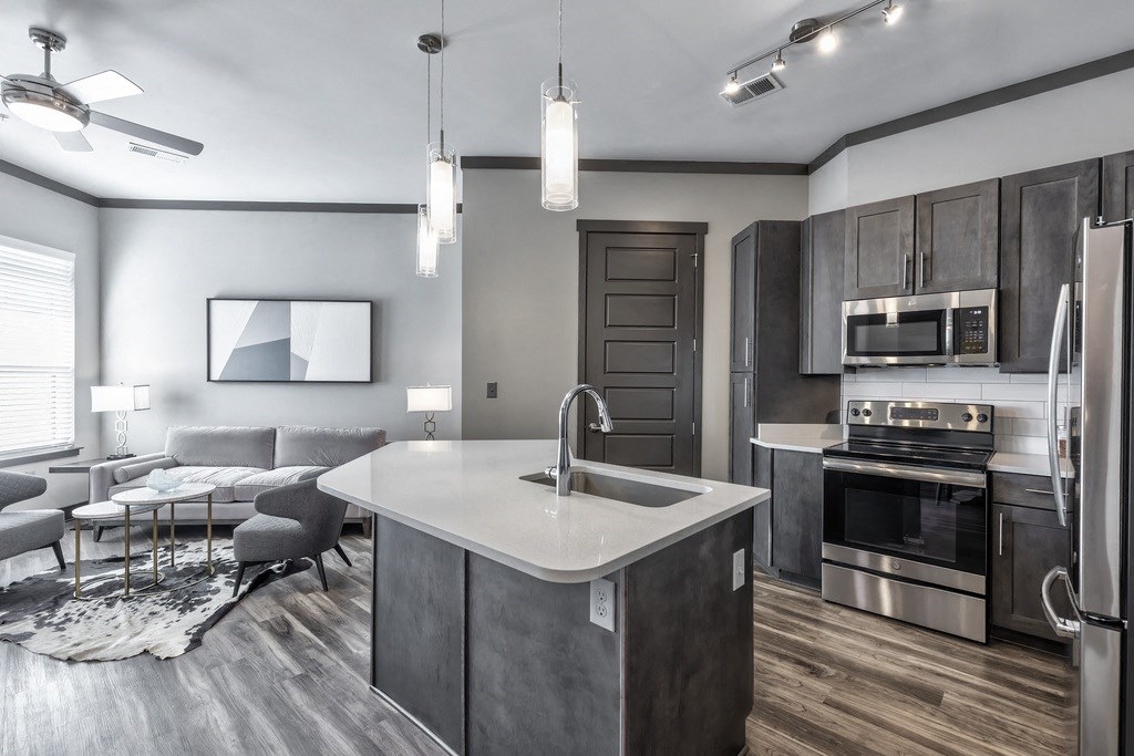 A modern kitchen with a large island and stainless steel appliances.