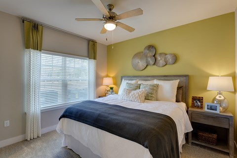 a bedroom with a bed and a ceiling fan