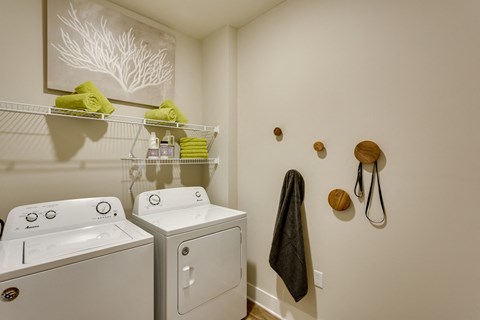 a laundry room with two washes and a dryer in it and a window