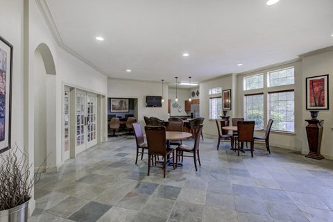 Clubhouse interior with dining area, clubhouse kitchen, hanging lights and fitness center in background
