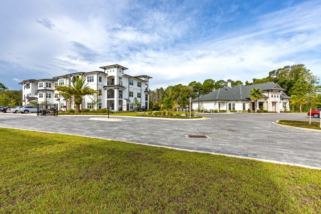 an empty parking lot with houses in the background