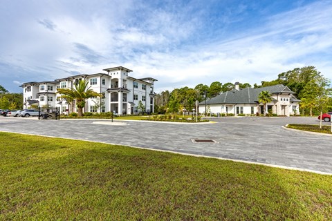 an empty parking lot with houses in the background