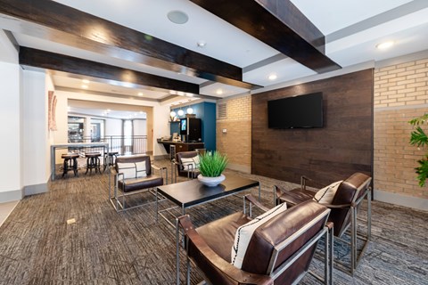 A modern living room with a brown leather couch and a flat screen TV mounted on the wall.