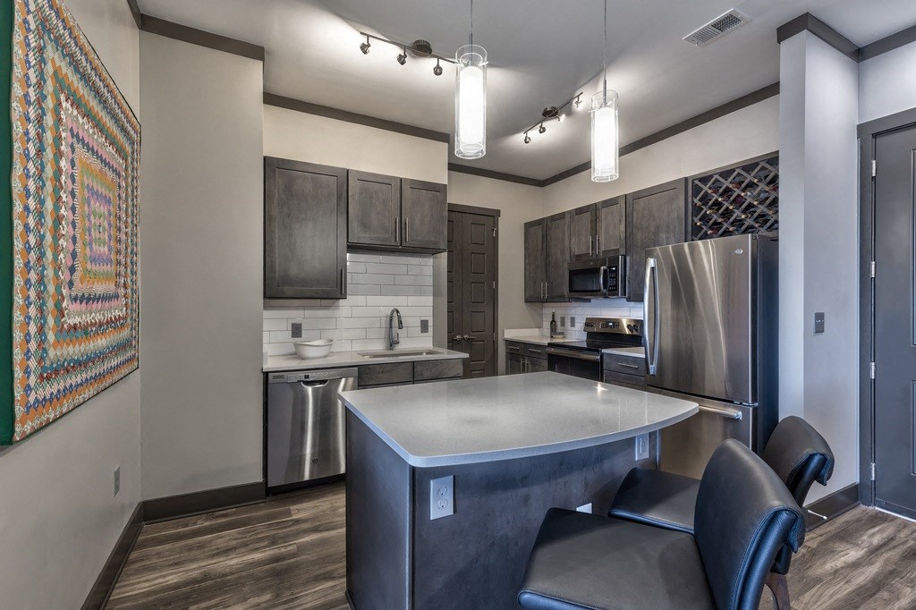A modern kitchen with a large island and stainless steel appliances.