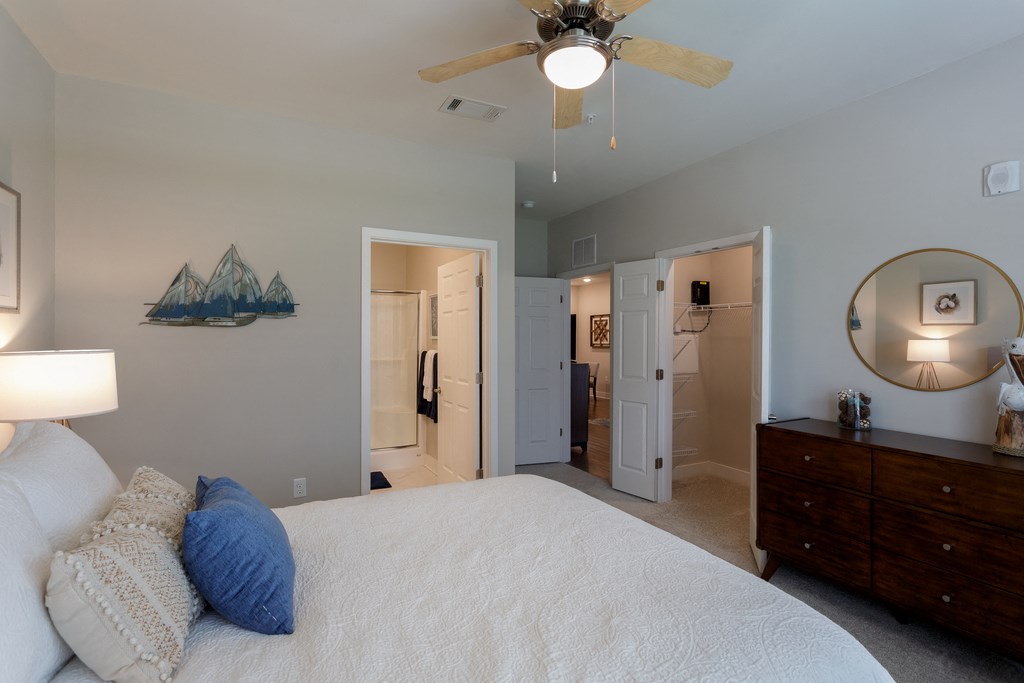 a bedroom with a large bed and a ceiling fan