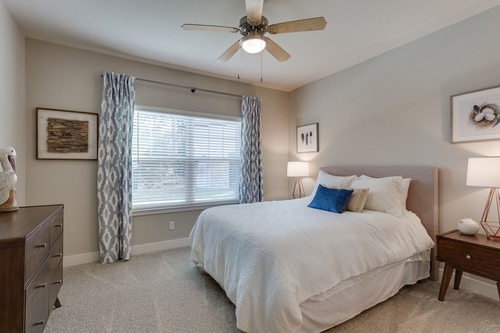 a bedroom with a large bed and a ceiling fan