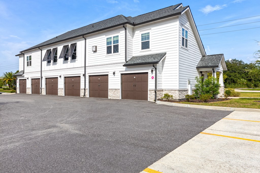 a white house with a row of garage doors