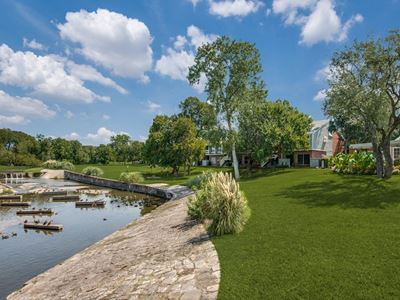 Grass area next to a creek with the apartment buildings in the background
