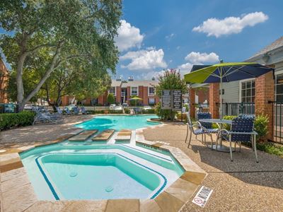 Swimming pool with pool umbrellas, tables and chairs.
