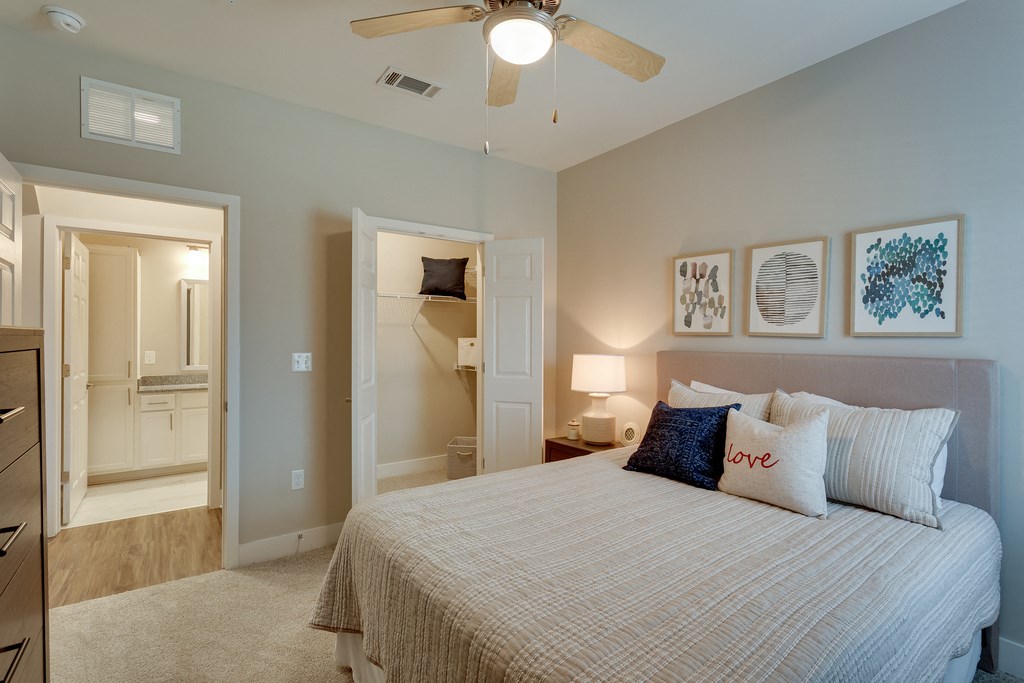 a bedroom with a large bed and a ceiling fan