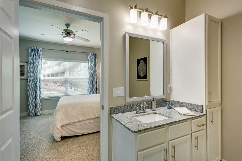 a bedroom with a bed and a sink and a mirror