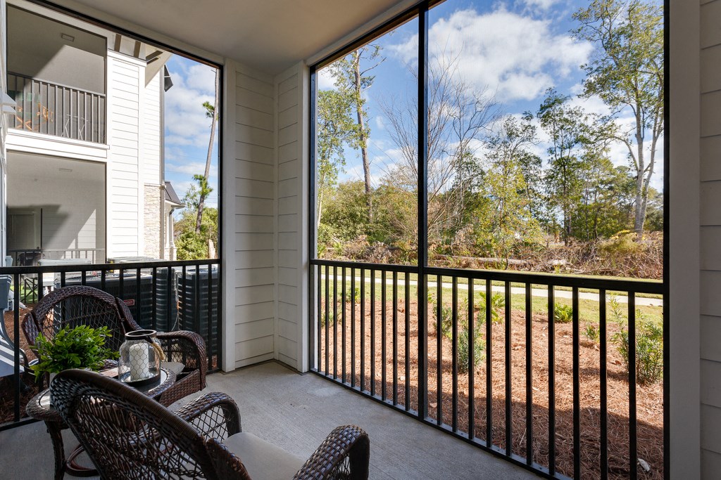 a covered porch with chairs and a table and a large window