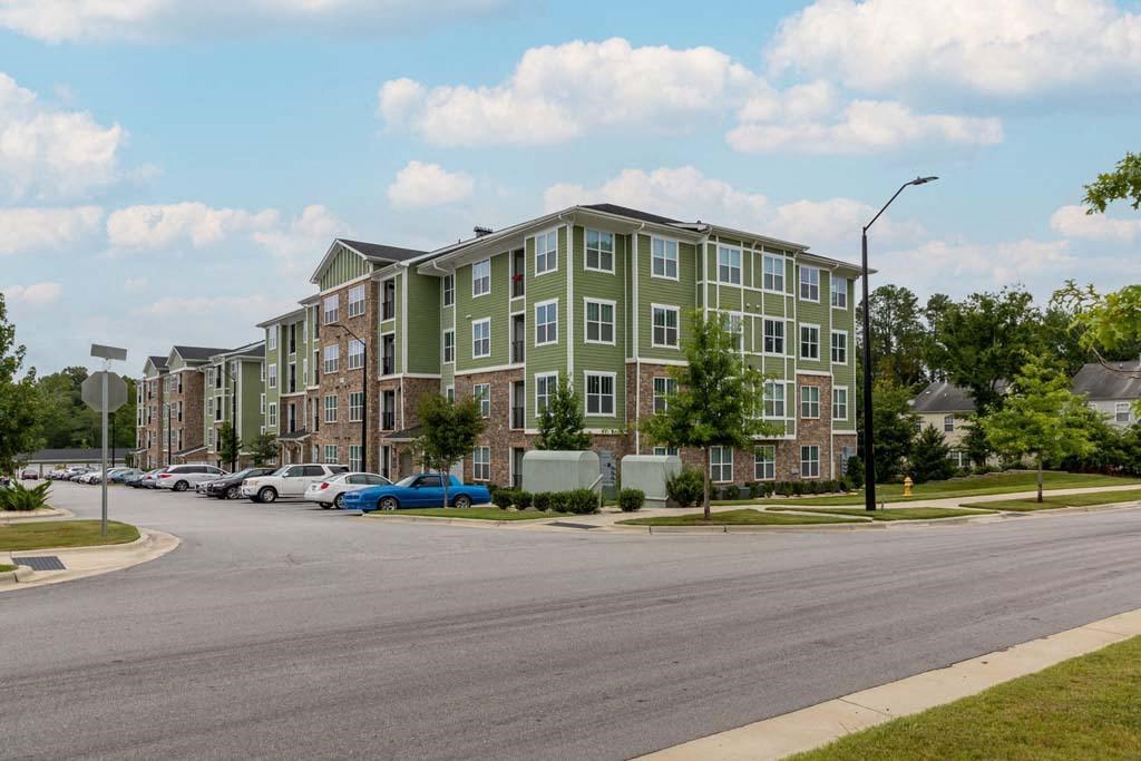 A street view of a residential area with apartment buildings and parked cars at Foxwood Apartments, Raleigh-Durham, NC