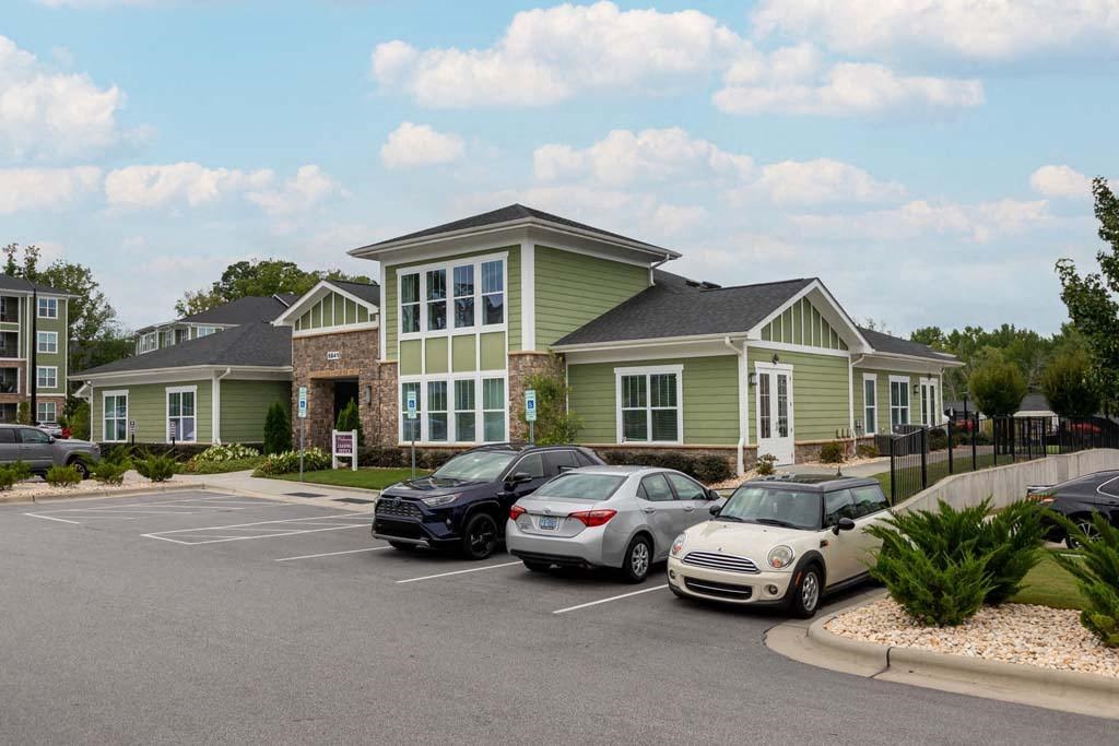 A parking lot with cars and a building in the background at Foxwood Apartments, North Carolina