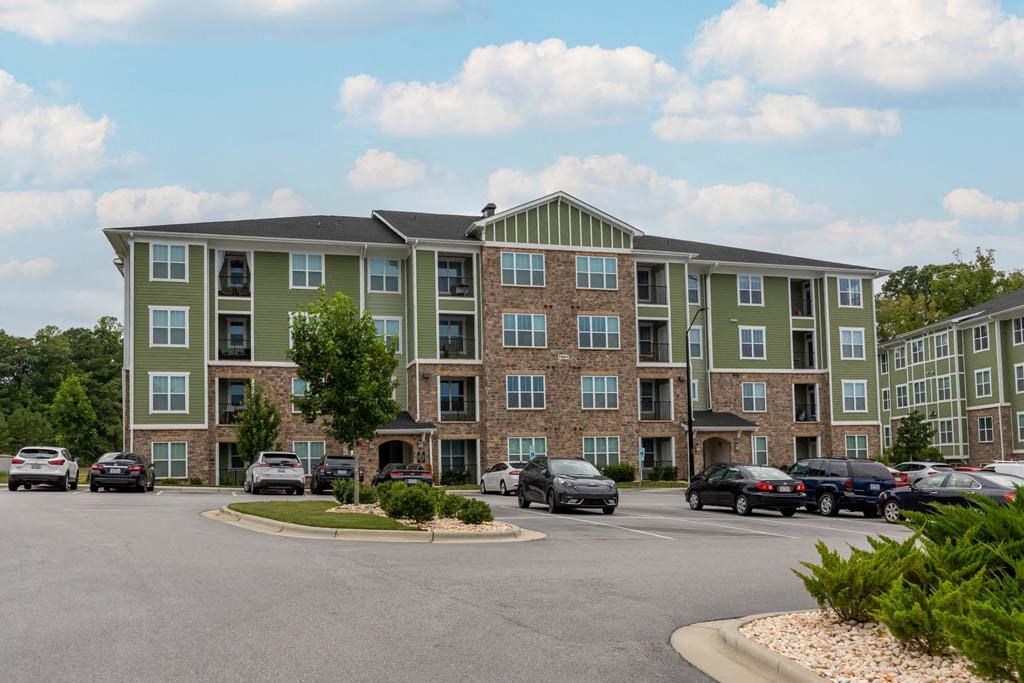 A large apartment complex with a parking lot in front at Foxwood Apartments, Raleigh-Durham, NC, 27616