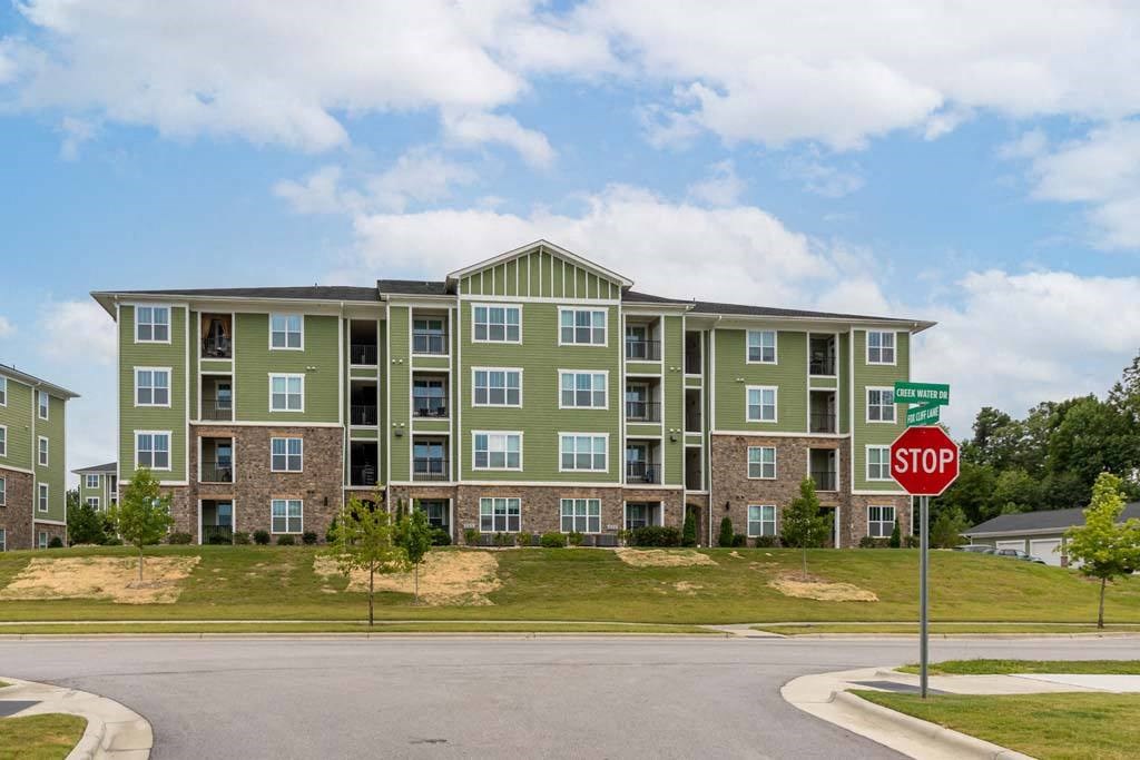 A stop sign is in front of a green apartment building at Foxwood Apartments, Raleigh-Durham, 27616