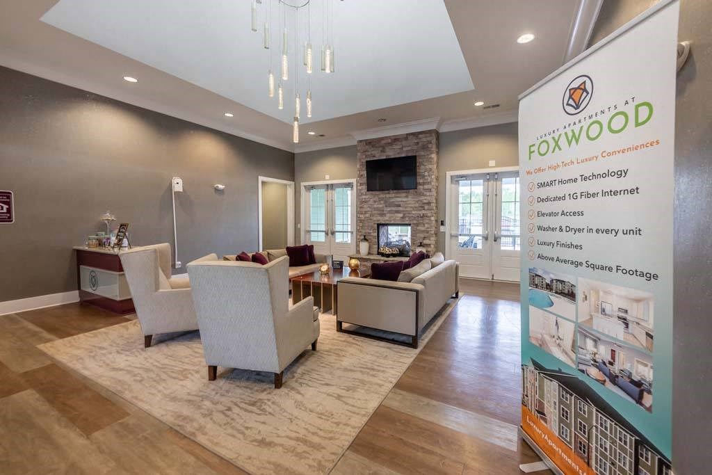 A living room with a sign that says Foxwood in front of it at Foxwood Apartments, Raleigh-Durham, NC, 27616